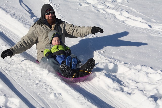 Dad sledding with his son